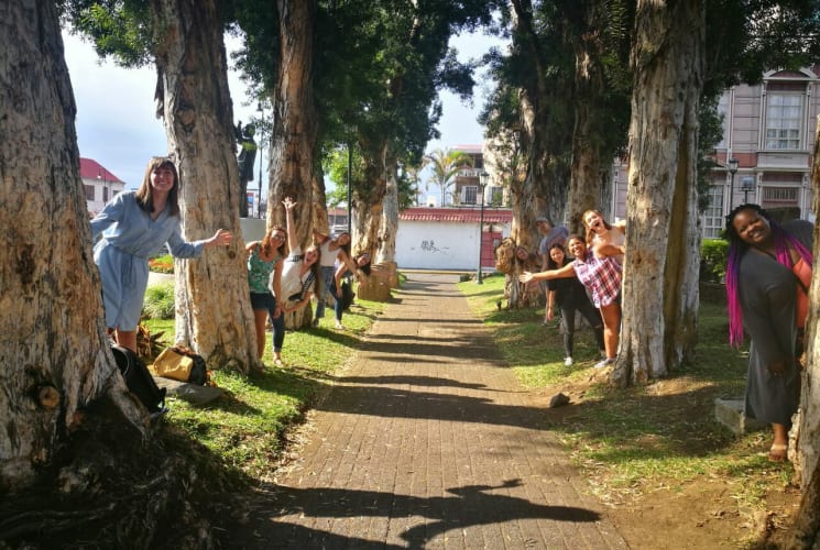 A group of students posing next to trees.